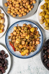 Olive varieties. Assortment of black and green olives on plate on gray background. Top view