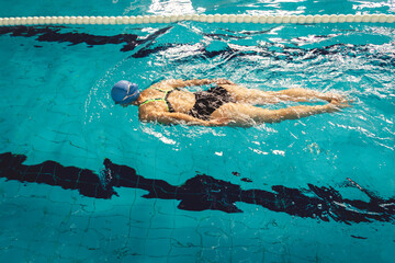 Woman swimming with swimming hat and swimsuit in swimming pool