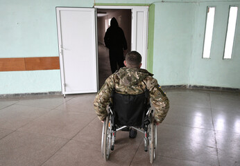 Ukrainian soldiers in a hospital. Wounded soldier in a wheelchair.