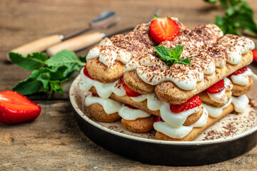 Tiramisu. Homemade tiramisu cake with fresh strawberry, biscuit and whipped cream and mint, Vegan lactose free dessert, Recipe of healthy organic decert