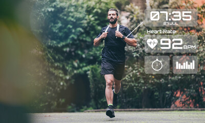 Man running in the park. Healthy runner with smart fit watch. Technology, training, health concept.