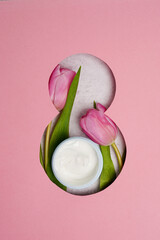 Eight march pink greeting card with tulips and cosmetics face cream, flat lay