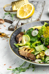 salad with smoked red fish with fresh vegetables, lettuce leaves on a white background, Food recipe background. Close up