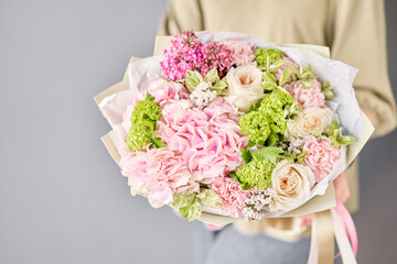 Florist woman creates beautiful bouquet of mixed flowers with hydrangea, lilac and peony roses by David Austin. European floral shop concept. Handsome fresh bunch. Education, master class and