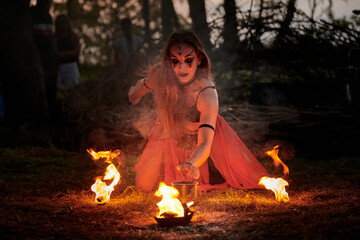 Girl fire dancing performance at outdoor art festival, smooth movements of female fire show artist...