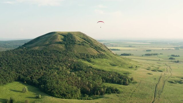 Southern Urals, a paramotor flies over Toratau Mount. Aerial view.