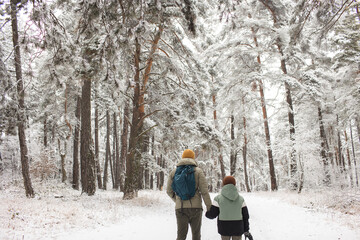 Fototapeta na wymiar Father and son walking in the forest with a backpack