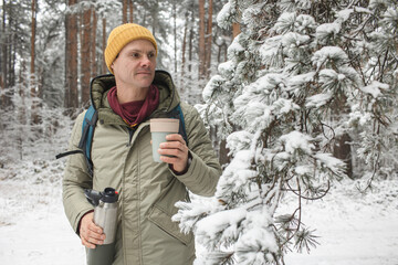 Man in the forest with a thermal mug