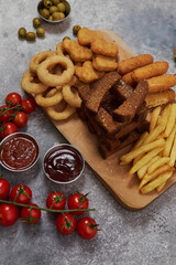 beer plate with breaded onion rings, croutons, french fries, cheese sticks, nuggets. serving with vegetables and sauces