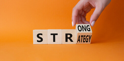 Strong Strategy symbol. Businessman Hand turns cubes with words Strong Strategy. Beautiful orange background. Business and Strong Strategy concept. Copy space