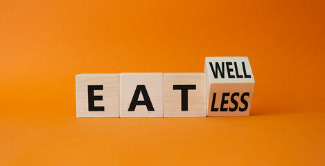 Eat less vs Eat well symbol. Turned wooden cube with words Eat less vs Eat well. Beautiful orange...