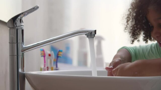 African-American child washes hands with soap. Realtime