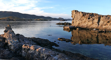 beautiful landscape of a lake with rocks in a bright sky