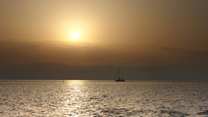 Beautiful sailboat with sunset at sunset in the ocean