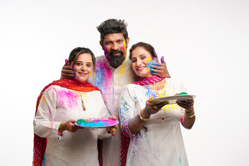 Indian man applying color on women face and celebrating holi festival.