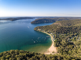 Aerial drone view of Great Mackerel Beach and Wharf on the western shores of Pittwater in Ku-ring-gai Chase National Park, Sydney, NSW, Australia. Mackerel can be reached via ferry from Palm Beach.