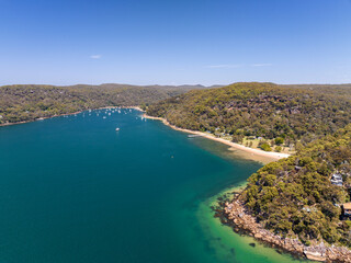 Aerial drone view of Currawong Beach and The Basin on the western shores of Pittwater in Ku-ring-gai Chase National Park, Sydney, NSW, Australia. Currawong can be reached via ferry from Palm Beach.