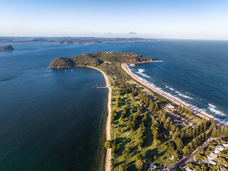 High angle aerial evening drone view of Palm Beach and Barrenjoey Head and Lighthouse. Palm Beach is an affluent beachside suburb in the Northern Beaches region of Sydney, New South Wales, Australia.