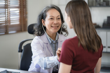 Fototapeta premium Doctor with stethoscope examining patient with examination, presenting symptoms and recommending treatment, healthcare and medical concept.