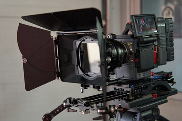 professional movie camera in full equipment. camera cube, professional lens, compendium, rechargeable battery, handles and camera trolley