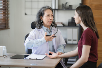 Doctor with stethoscope examining patient with examination, presenting symptoms and recommending treatment, healthcare and medical concept.