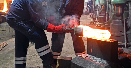The interior of the forge. Blacksmiths during the process of forging iron. Forging of steel parts.