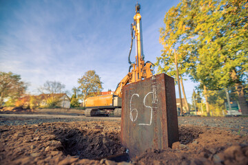 Factory construction site with steel soil and vibratory hammer in background