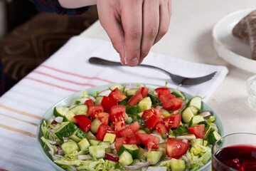 Dinner table with vegetable salad and red wine in a glass