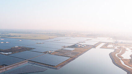 Fototapeta na wymiar Solar Photovoltaic of solar farm aerial view, solar plant rows array of on the water mount system Installation in earthen pond, Floating solar or floating photovoltaics (FPV). Morning scene,