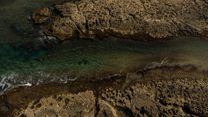 Abstract natural background with turquoise sea and rocks aerial view. 