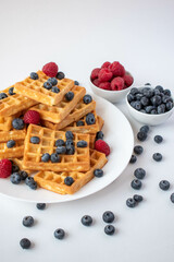 Traditional Belgian waffles with blueberries and raspberries for breakfast