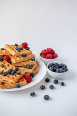 Traditional Belgian waffles with blueberries and raspberries for breakfast