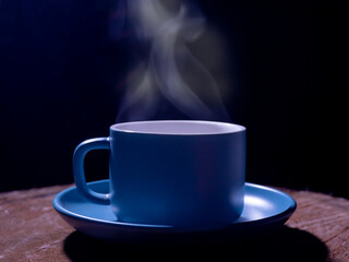 blue coffee mug on the old wooden floor in the black background,