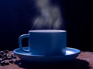 blue coffee mug on the old wooden floor in the black background,