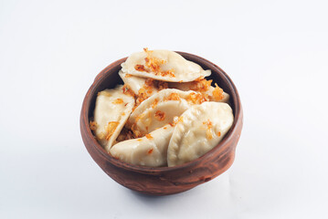 Boiled dumplings seasoned with spices in a plate on a white background.