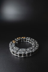 New timing chain of an internal combustion engine on a black background in selective focus. Spare parts new