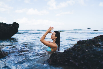 Relaxed woman in sea near rocks