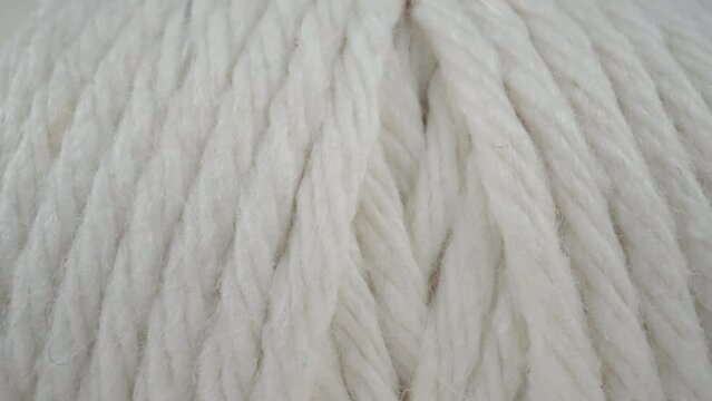 Macro shot spool of hemp rope on white background. Slider dolly extreme close-up roll of thread. Laowa 24mm probe lens camera glides over white threads