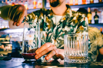 man hand bartender making cocktail in glass on the bar counter