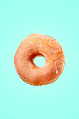 Fototapeta na wymiar Delicious traditional donut with sugar and cinnamon isolated on blue background. Modern food concept. Advertising for pastry shops, cafes.