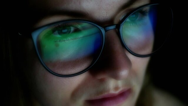 Businesswoman works on internet. Reflection at the glasses from laptop. Eye protection from blue light and rays.