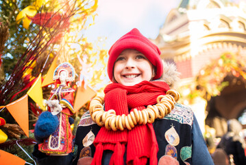 A happy boy holds in his hands a Russian doll in a kokoshnik, celebrates Shrovetide, a week of...