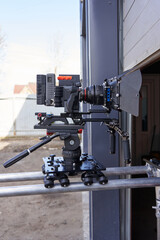 a professional movie camera is standing outside on a film set on a camera trolley and rails side view