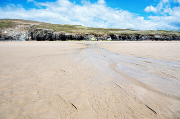 Fototapeta na wymiar Sandy beach of Perranporth in West Cornwall, South West England. View of the beach, blue sea and cliffs. Selective focus