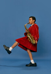 Portrait of cute little african boy wearing huge man's jacket and shoes like jazz man playing on...