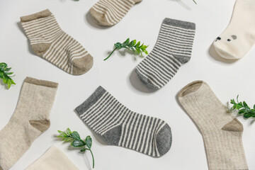 Children's socks in warm colors for newborn boys or girls lie in a chaotic manner on a white...