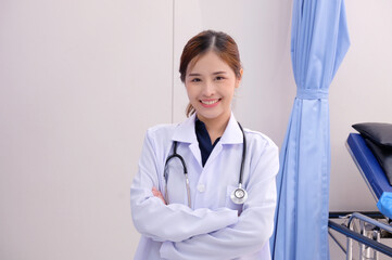 Smiling Asian female doctor in medical gown with stethoscope on her shoulder medical concept.