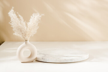 Marble round podium with vase and pampas grass, warm shadows. Display for home product...