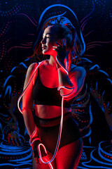 Sexy beautiful young woman in fashionable youth club clothes in neon light.Red, purple, blue neon lights. Nightlife