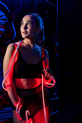 Sexy beautiful young woman in fashionable youth club clothes in neon light.Red, purple, blue neon lights. Nightlife